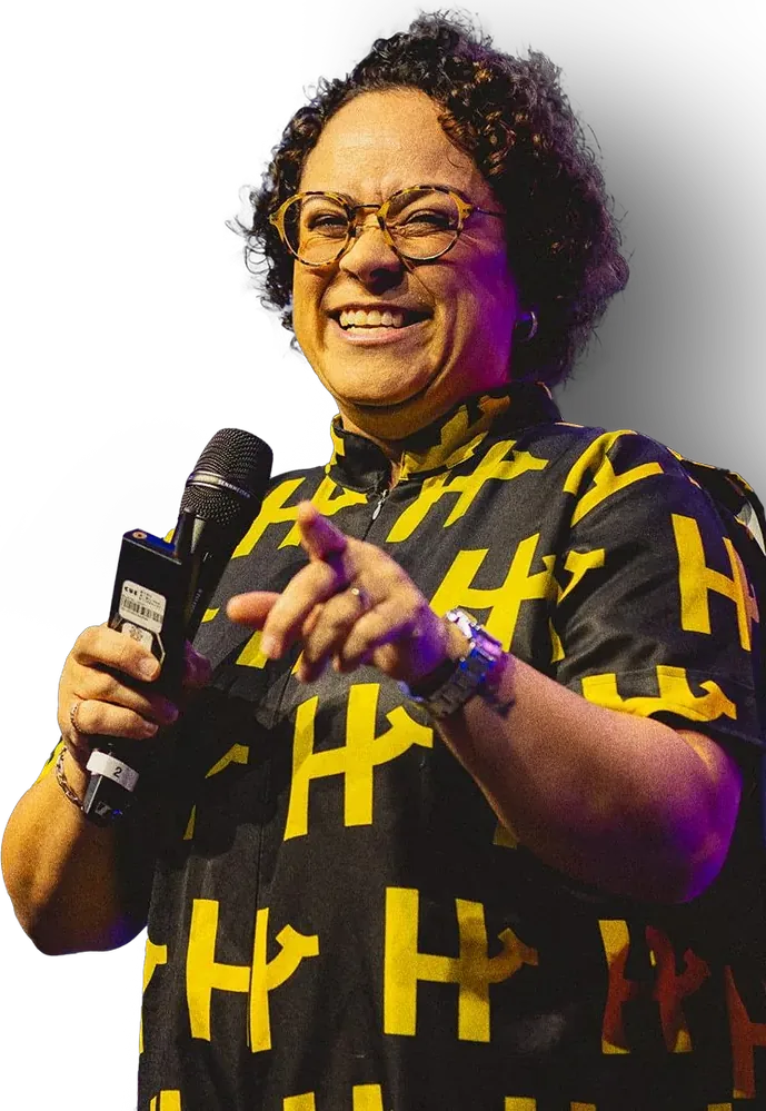 Maryana com Y, coordenadora da coleção, sorrindo com um microfone na mão